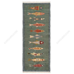 Könnte beinhalten: Ein rechteckiger Läufer mit salbeigrünem Hintergrund, der elf stilisierte Fische in einer vertikalen Reihe zeigt. Jeder Fisch weist ein einzigartiges Muster und eine eigene Farbkombination auf, darunter Rot-, Orange-, Blau- und Cremetöne. Der Teppich hat eine dunkelblaue und weiße geometrische Bordüre sowie Fransen an den Enden.