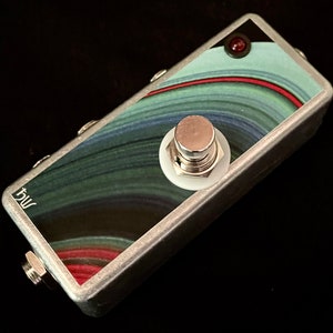 May include: A silver foot pedal with a single large button and a red LED light. The pedal has a colorful abstract design with green, blue, and red swirls.