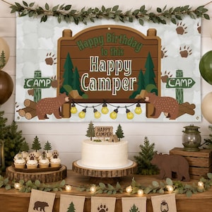 May include: A rectangular banner featuring a brown wooden sign with the text Happy Birthday to this Happy Camper, surrounded by green pine trees, brown bears, and string lights. The background is a light gray pattern with brown bear paw prints.