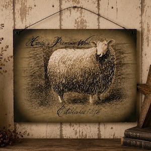 Könnte beinhalten: Ein rechteckiges Wandschild mit einer sepiafarbenen Illustration eines Schafes. Der Text Hardy's Premium Wool ist über dem Schaf aufgedruckt, und Established 1892 steht darunter. Das Schild ist an einem dünnen schwarzen Draht aufgehängt.