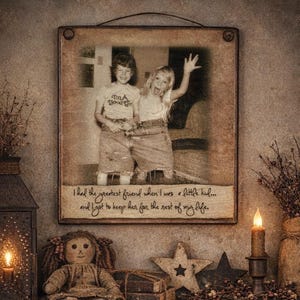 May include: A framed photograph featuring two children, one wearing a shirt that says "I'm a Good Girl". The frame has a quote: "I had the greatest friend when I was a little kid... and I got to keep her for the rest of my life."