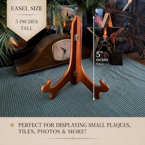 May include: A brown wooden display easel with a hinged design and two curved supports at the base. The easel features a vertical height of 5 inches as indicated by the text and measurement graphic. The structure is designed to hold items upright.