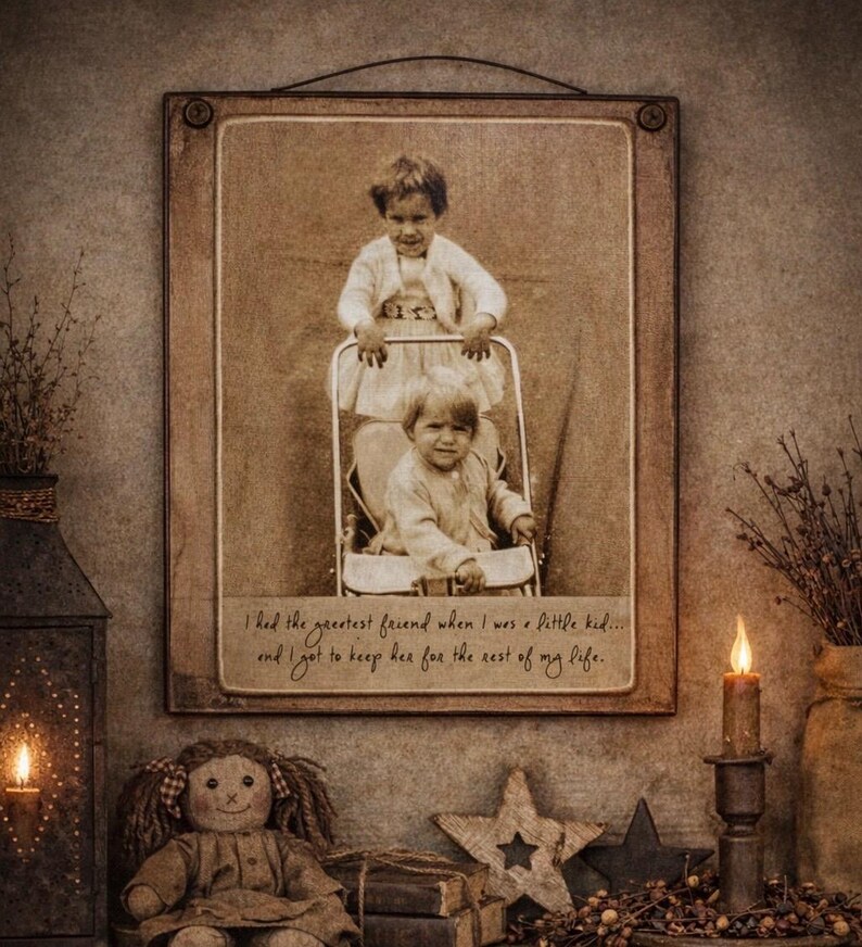 May include: A framed sepia-toned photograph of two children in a stroller. The frame is wooden and has a wire for hanging. The text on the photo reads, "I had the greatest friend when I was a little kid... and I got to keep her for the rest of my life."