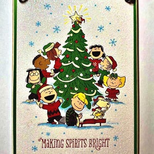 Noël Charlie Brown faisant des spiritueux lumineux / Belles paillettes blanches scintillantes / Plaque en bois avec support ou carte de voeux / 4,5 x 6,5 po.