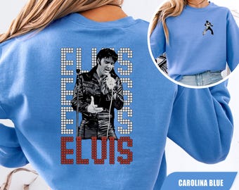 Könnte beinhalten: Ein karolinablaues Sweatshirt mit Rundhalsausschnitt, das auf der Rückseite eine schwarz-weiße Grafik von Elvis Presley und den Namen ELVIS in weißen und roten Blockbuchstaben zeigt. Eine kleinere schwarz-weiße Grafik ist vorne links aufgedruckt.
