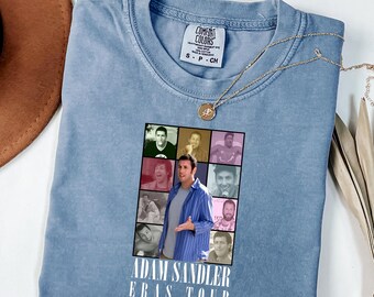 Könnte beinhalten: Ein blaues T-Shirt in Jeansoptik mit einer Collage aus Adam Sandler-Fotos in einem Raster. Unter den Bildern steht der Text ADAM SANDLER ERAS TOUR in weißen Großbuchstaben. Das T-Shirt hat einen Rundhalsausschnitt und ein Comfort Colors Etikett.