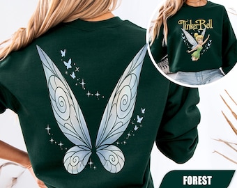 Könnte beinhalten: Ein dunkelgrünes Sweatshirt mit Rundhalsausschnitt und einem großen Motiv schillernder Feenflügel auf der Rückseite. Im Brustbereich befindet sich eine kleinere Grafik von Tinker Bell mit dem Schriftzug Tinker Bell in goldener Schrift.