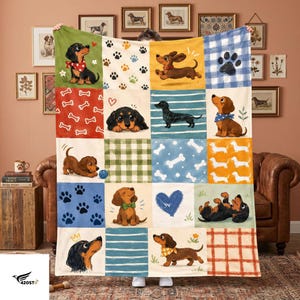May include: A multi-paneled throw blanket featuring a repeating pattern of dachshund dogs in various poses, paw prints, bones, hearts, and geometric designs in shades of red, blue, green, yellow, and white, with a soft, plush fabric texture.