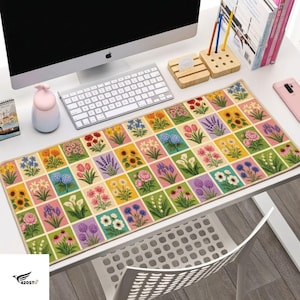 May include: A rectangular desk mat featuring a grid pattern of various colorful flower illustrations, including sunflowers, tulips, lavender, and daisies, set against a light background with a stitched border edge.
