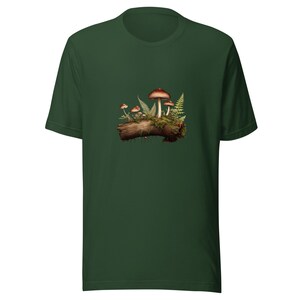 May include: A dark forest green short-sleeve t-shirt featuring a central graphic print of several brown-capped mushrooms growing on a textured brown log, surrounded by small green fern fronds and patches of mossy vegetation.