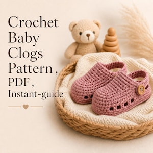Könnte beinhalten: Ein Paar altrosa gehäkelte Baby-Clogs mit seitlichen Knöpfen, die in einem geflochtenen Korb auf cremefarbenem Stoff liegen. Der Text lautet: Crochet Baby Clogs Pattern, PDF, Instant-guide. Ein kleines Herzsymbol befindet sich unter dem Text.