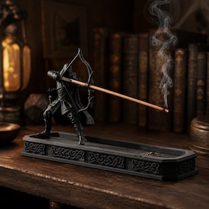 Hooded archer incense burner displayed in a dark fantasy reading nook with smoke rising from the incense arrow