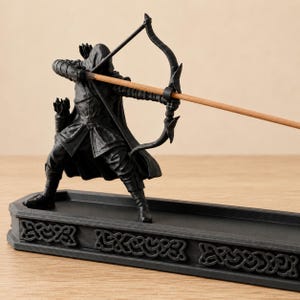 Close view of the black 3D-printed archer, sculpted bow, quiver, armor, incense arrow, and ornate knotwork base