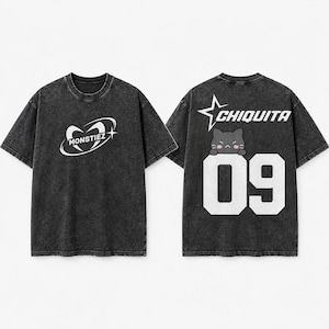 May include: A charcoal grey acid-wash t-shirt shown from the front and back. The front features a white oval logo with the text MONSTIEZ. The back displays a white star, the text CHIQUITA, a small black cat graphic, and the large white number 09.