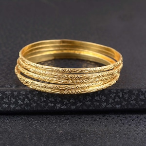 Set di 7 bracciali rigidi in oro 18 carati, impilabili.