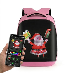 Könnte beinhalten: Ein rosa Rucksack mit einer schwarzen Frontplatte, die ein programmierbares LED-Display mit einem pixeligen Weihnachtsmann zeigt, der Geschenke hält. Ein Smartphone im Vordergrund zeigt die Benutzeroberfläche der Santa Editor App.