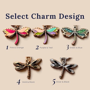 A selection of five dragonfly charms labeled Select Charm Design. 1 is pink and orange, 2 is purple and teal, 3 is green and blue, 4 is gold and black, and 5 is silver and black. Each charm features detailed wings and a body.