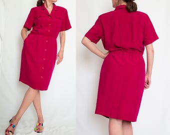May include: A magenta button-down dress with short sleeves and a knee-length skirt.