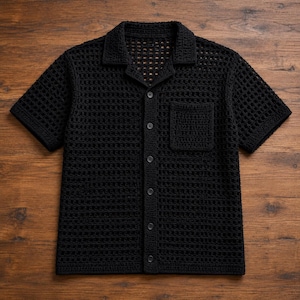 May include: A black short-sleeve shirt crafted with an open-knit crochet texture. This button-down garment features a classic collar, a single chest pocket on the left side, and a straight hemline, showcasing a uniform grid-like pattern throughout.