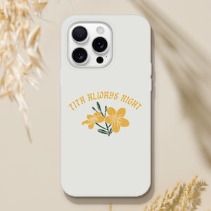 Puede incluir: Una funda de smartphone gris claro con un recorte para la cámara de triple lente en la parte superior. El centro de la funda muestra un gráfico de dos flores amarillas con tallos y hojas verdes, junto al texto TITA ALWAYS RIGHT en letras amarillas.
