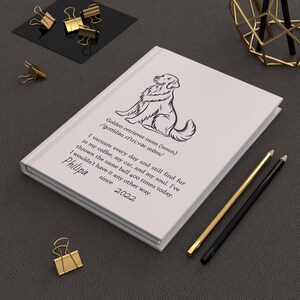 Puede incluir: Un cuaderno de tapa dura blanco con un dibujo lineal negro de un golden retriever. El texto dice: Golden retriever mom (noun) /ɡoʊldən rɪˈtriːvər mɑːm/ I vacuum every day and still find fur in my coffee, my car, and my soul. I've thrown the same ball 400 times today. I wouldn't have it any other way. Philipa since 2022.