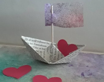 whimsical paper sail boat with heart and flag