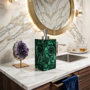 Puede incluir: Un dispensador de jabón rectangular con un patrón de malaquita verde intenso y un mecanismo de bomba de metal plateado pulido. El dispensador tiene una construcción sólida y lisa, diseñada para dispensar jabón líquido o loción.