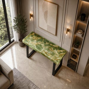 May include: A rectangular console table featuring a polished green onyx stone top with white and gold veining, supported by a black metal frame. The surface displays a natural marbled pattern with translucent qualities and smooth edges.