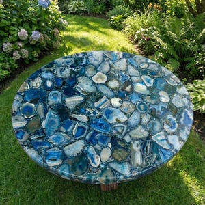 May include: A round table top featuring a mosaic of polished blue and white agate slices. The surface displays a variety of natural stone shapes in shades of deep navy, sky blue, and translucent white, arranged to create a continuous pattern.