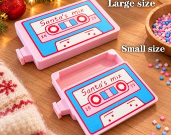 May include: Two rectangular pink dot diamond trays featuring a blue cassette tape graphic with the text Santa's mix. One tray is labeled as Large size and the other as Small size. The trays have a recessed interior and a small tab on the side.