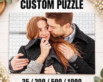 May include: A rectangular custom puzzle featuring a photograph of two people embracing. The text CUSTOM PUZZLE appears at the top, and the numbers 35 / 300 / 500 / 1000 are printed at the bottom of the puzzle image.