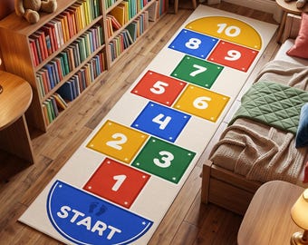 May include: A rectangular area rug featuring a colorful hopscotch game design on a white background. The rug displays a blue semi-circle start section, followed by numbered squares from one to ten in red, yellow, green, and blue, ending in a yellow semi-circle.
