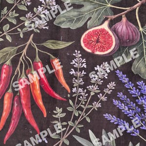 Op de afbeelding: Een donkerbruine stof met een botanische print van knoflookbollen, een schijfje citroen, vijgen en bladeren, rode chilipepers, lavendeltakjes, een artisjok en donkerpaarse olijven met groene bladeren verspreid over het oppervlak.