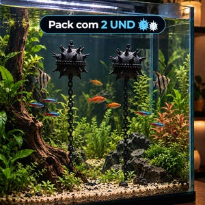 Op de afbeelding: Twee zwarte bolvormige zeemijn aquariumdecoraties met uitstekende stekels, elk bevestigd aan een verticale kettingbasis. De tekst "Pack com 2 UND" wordt weergegeven in een blauw omrande zwarte ovaal bovenaan het glazen aquarium.