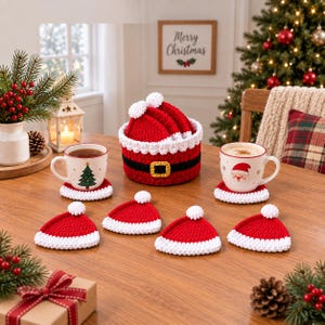 May include: A set of crochet coasters shaped like Santa hats in red and white, stored in a matching round crochet basket with a black belt and yellow buckle design. The set includes six individual hat-shaped coasters on a wooden table surface.