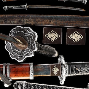 May include: A katana sword featuring a dark, weathered steel blade, a reddish-brown wooden scabbard with silver-toned metal fittings, and a black cord-wrapped handle. The circular handguard displays intricate relief carvings of swirling patterns.