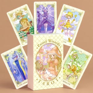 以下が含まれることがあります： Pastel Wizardsタロットカードデッキ。箱にはキャラクターのイラストと「Pastel Wizards Tarot」の文字が描かれています。箱の後ろには5枚のカードが扇状に広げられており、それぞれにカラフルなアニメスタイルのキャラクターが描かれています。