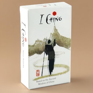 May include: A rectangular white box for an I Ching deck featuring a black ink-style illustration of a figure walking through a landscape with green hills and a red sun. The text reads I Ching, Klaus Holitzka, and Based on the Ancient Wisdom of China.