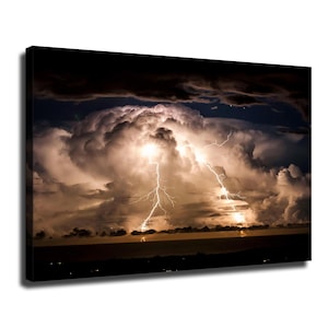 Puede incluir: Un lienzo rectangular que muestra una dramática escena nocturna de una enorme nube de tormenta iluminada sobre un horizonte oscuro. Brillantes rayos blancos caen desde el centro de las densas y texturizadas nubes hacia la distancia.