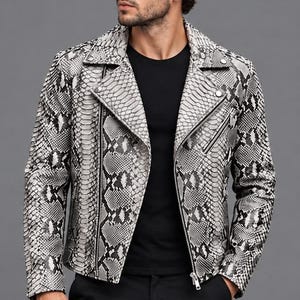 Peut inclure: Une veste de motard avec un motif peau de serpent noir et blanc, un revers cranté avec des boutons-pression en métal argenté, une fermeture éclair frontale diagonale et une poche poitrine zippée, portée sur un t-shirt noir et un pantalon noir.