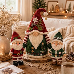 May include: A large central crochet gnome with a red hat featuring a white snowflake, pinecone, and greenery, wearing a green body with wooden buttons. Flanking the gnome are two smaller crochet Santa figures, one in red and one in green attire.