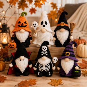 Könnte beinhalten: Sechs gehäkelte Halloween-Wichtel in verschiedenen Kostümen: ein Kürbis, ein Geist, eine Hexe mit Besen, ein Vampir mit Umhang und Fledermaus, ein Skelett mit Totenkopfstab und eine Hexe mit Kessel, alle mit weißen Bärten aus Garn.