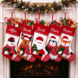 Puede incluir: Cinco calcetines navideños blancos y rojos con los nombres bordados Alfie, Noah, Scott, Claire y Harper. Cada calcetín muestra un personaje de peluche: muñeco de nieve, reno, Santa, pingüino y zorro, todos con bufandas de lunares rojos y blancos.