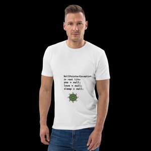 May include: A white short-sleeved t-shirt featuring black text that reads NullPointerException in real life: you = null; love = null; sleep = null; and a small green circular graphic icon positioned below the printed text on the front.