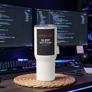 May include: A white stainless steel tumbler featuring a black rectangular graphic with the red text ERROR 404 and white text SLEEP NOT FOUND, followed by the smaller text try coffee.exe. The tumbler has a clear lid and a tapered cylindrical body.