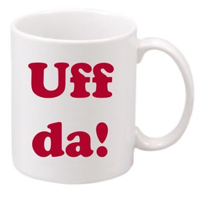 May include: White ceramic mug with a red inscription that reads "Uff da!"