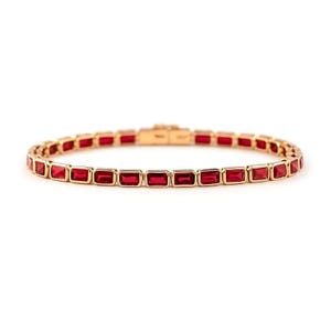 Peut inclure: Un bracelet doré composé d'une rangée continue de pierres précieuses rectangulaires rouge foncé, serties dans des cadres métalliques individuels. Le design comprend un mécanisme de fermoir intégré et sécurisé au centre, formant une structure circulaire.