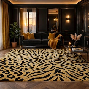 Op de afbeelding: Een rechthoekig vloerkleed met een opvallend, herhalend patroon van zwarte luipaardvlekken en zebrastrepen op een goudgele achtergrond. Het kleed ligt op een donkere houten vloer in een kamer met donkere muren, een bank en gouden accenten.