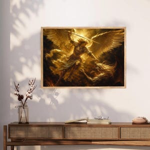 May include: A rectangular wall art print featuring a golden-toned illustration of a winged figure in armor wielding a sword against a dark, horned creature. The artwork is displayed in a wooden frame, capturing a dramatic scene of conflict.