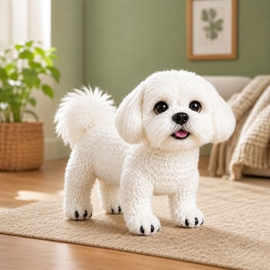Pode incluir: Um cão de peluche feito em croché branco com textura fofa, olhos grandes castanho-escuros, nariz preto e uma pequena língua rosa visível. O brinquedo tem orelhas caídas, uma cauda curta e pequenos detalhes pretos bordados nas patas.